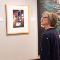 Woman looking at artwork on wall